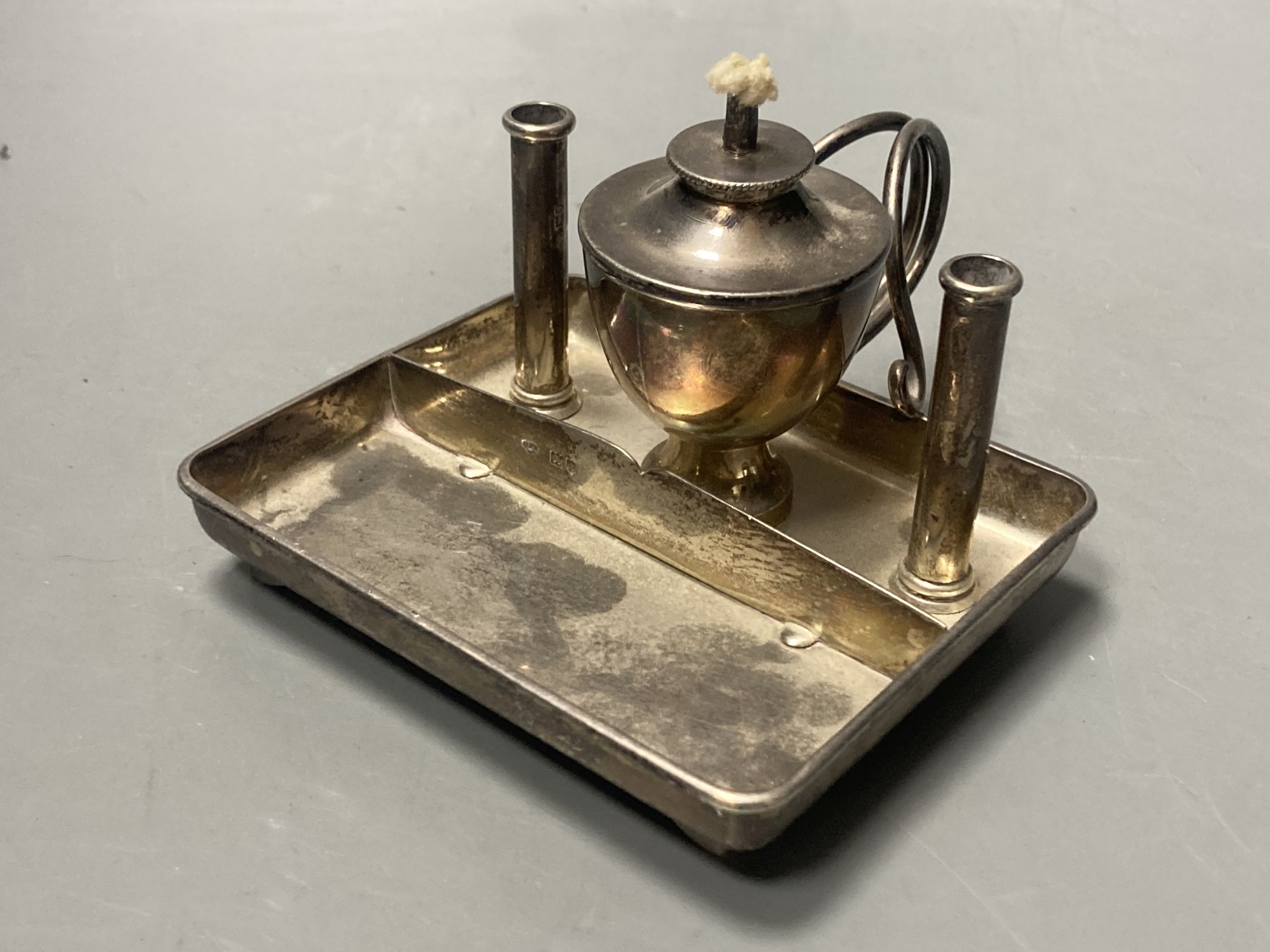 A George V silver square table lighter with wick and two cylindrical compartments (incomplete?), London, 1913, 10.9cm.
